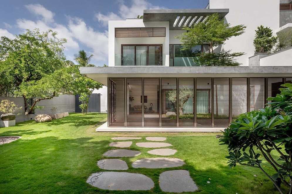 Biệt thự sân vườn ở quê hiện đại với lối đi lát đá cuội trên nền cỏ xanh