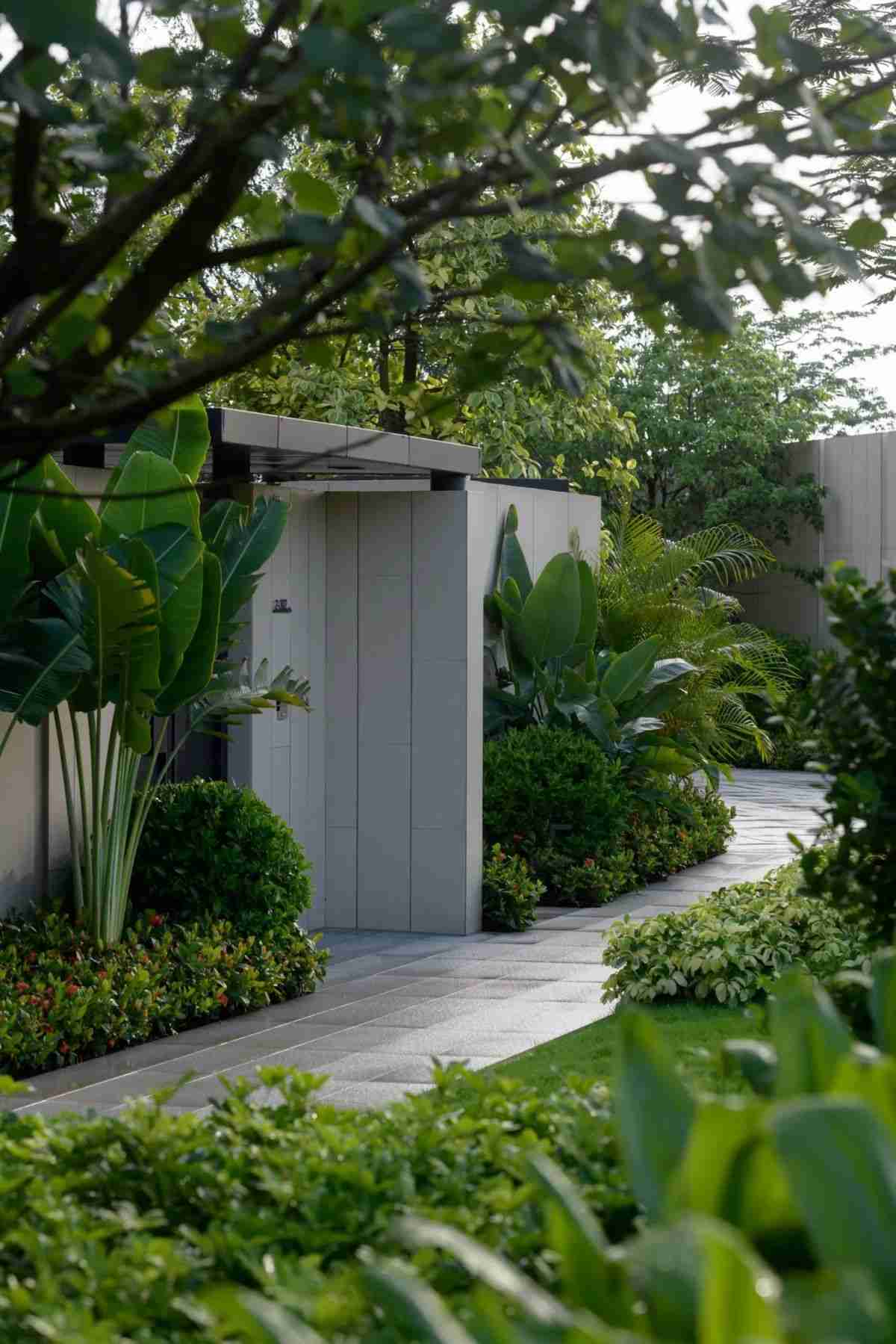 Không gian sân vườn với cây nhiệt đới bao quanh lối đi lát đá sang trọng