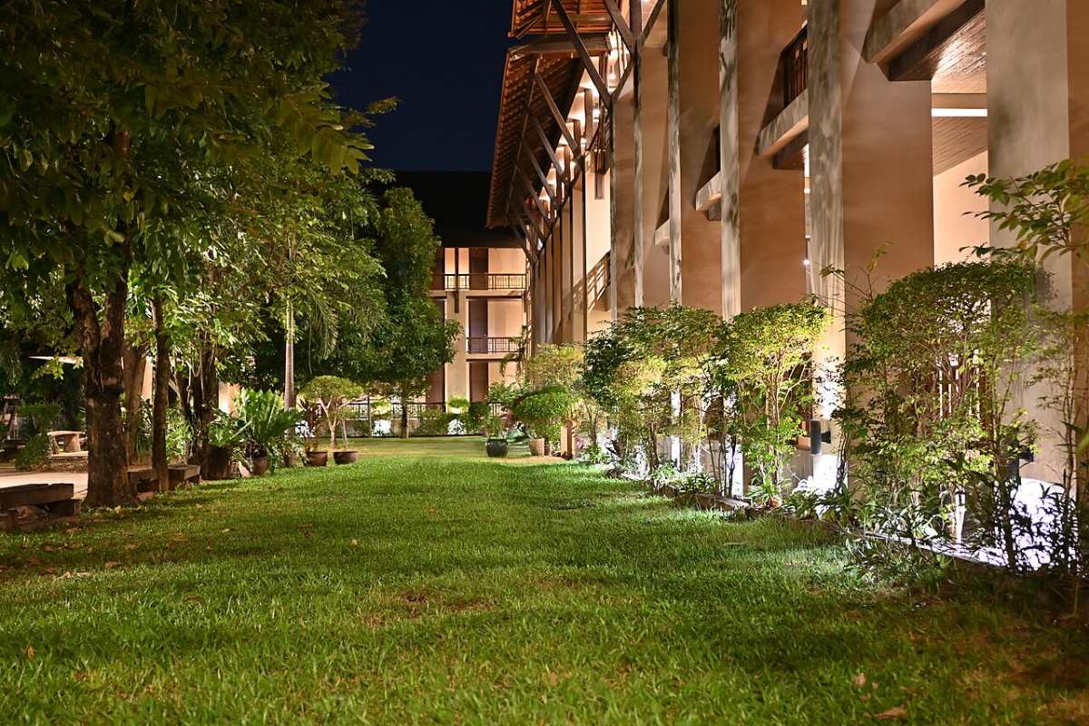 Thiết Kế Sân Vườn Villa Nghỉ Dưỡng: 8 Nguyên Tắc Đẹp Như Resort 2026 6 Chiếu sáng sân vườn villa ban đêm bằng đèn hắt gốc cây ánh vàng ấm