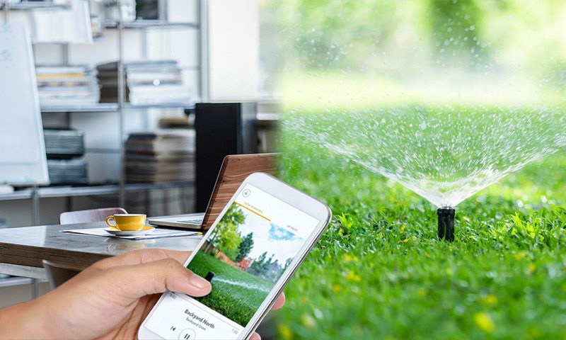 Hệ thống tưới cây tự động điều khiển qua smartphone, phun nước đều trên bãi cỏ xanh, kết hợp công nghệ hiện đại và tiện ích từ xa.