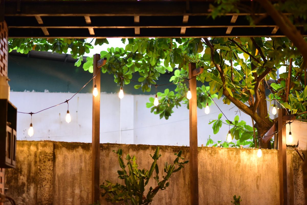 Giàn pergola trong vườn với đèn dây ánh vàng