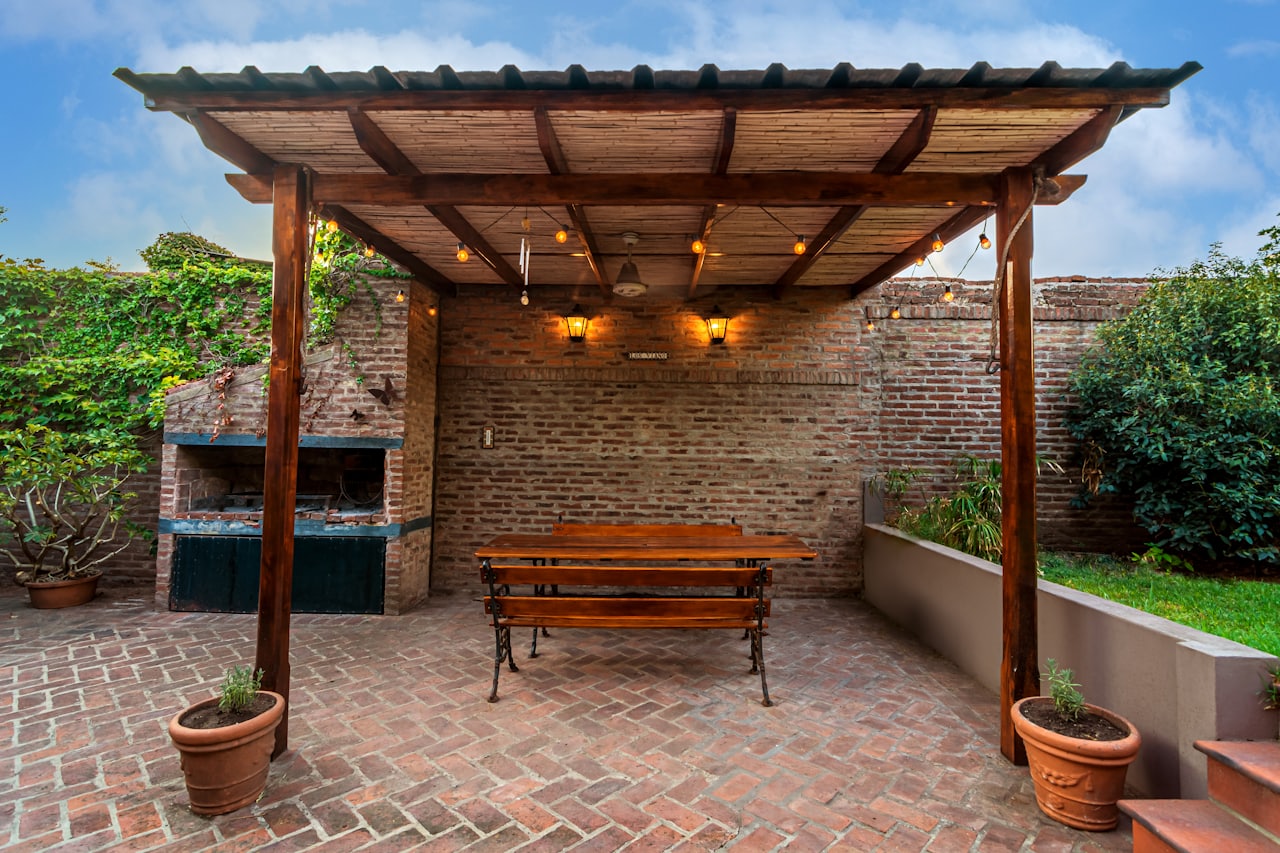 Pergola ngoài trời bằng gỗ phủ cây leo trên sân gạch