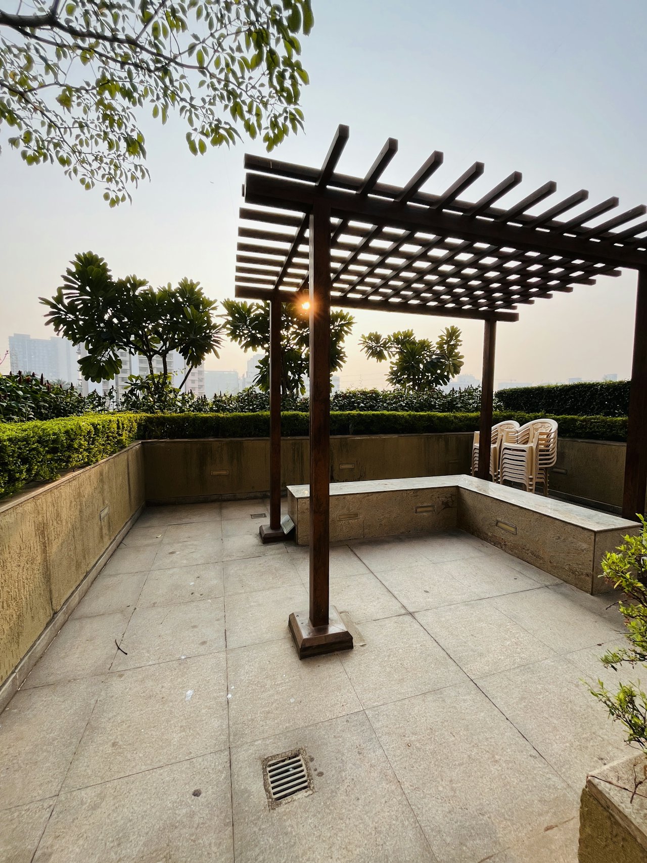 Pergola ngoài trời che khu ghế ngồi giữa cây xanh