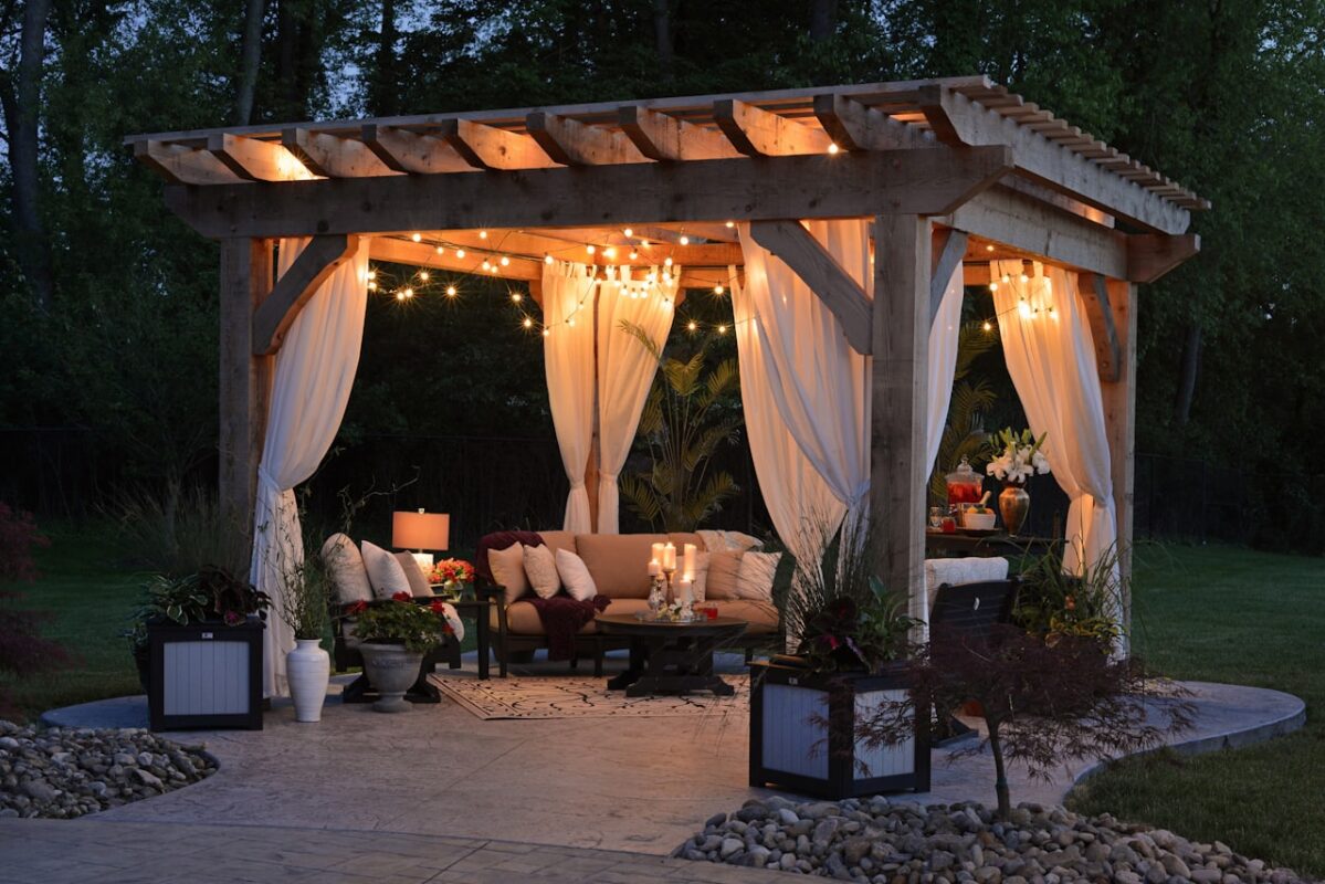 Pergola ngoài trời bằng gỗ với rèm và đèn trang trí ấm cúng