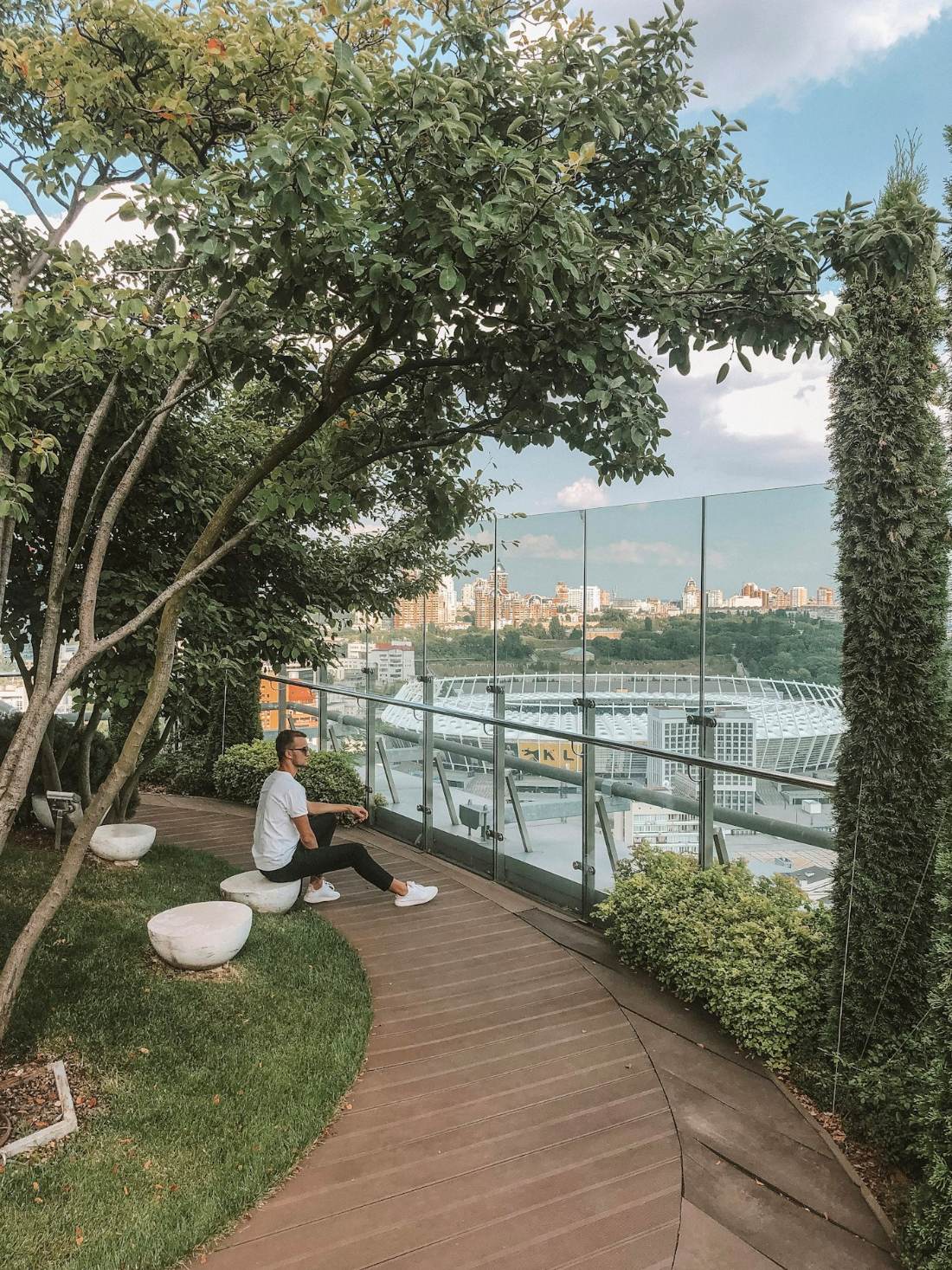 Thiết Kế Cảnh Quan Căn Hộ Penthouse: 7 Ý Tưởng Đẹp Đẳng Cấp 2026 3 Sân vườn penthouse với sàn gỗ, cây xanh và view thành phố