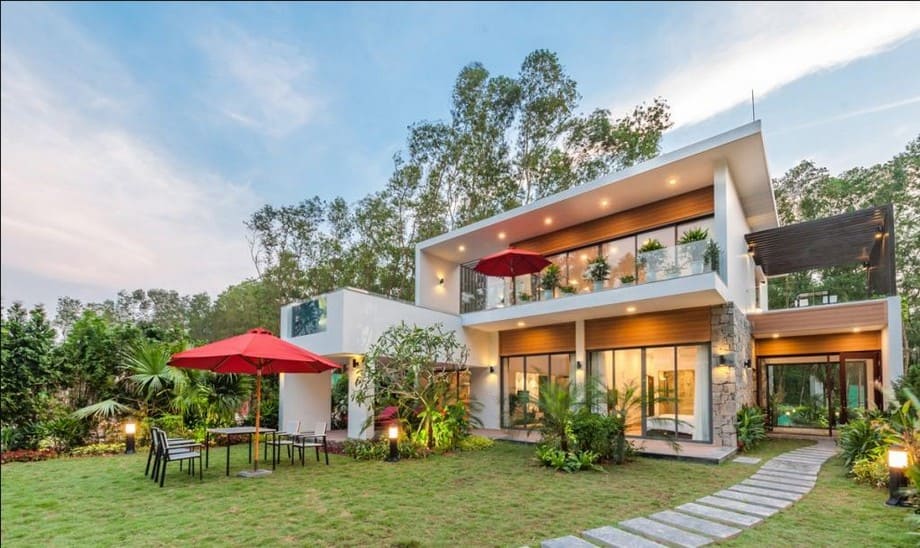 Thiết Kế Sân Vườn Hết Bao Nhiêu Tiền?Thiết Kế Sân Vườn Bao Nhiêu Tiền? Cập Nhật Giá Mới Nhất 2025Thiết Kế Sân Vườn Hết Bao Nhiêu Tiền? 2 Thiết kế cảnh quan biệt thự với sân vườn cỏ xanh, lối đi đá, ô che nắng đỏ và không gian ngoài trời thư giãn.