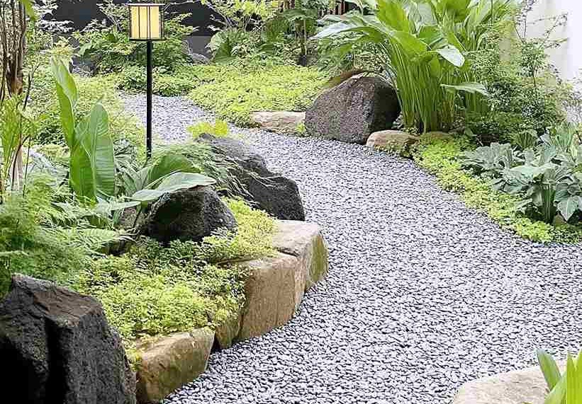 Lối đi sân vườn trải sỏi trắng xen đá lớn, cây bản địa và đèn sân vườn