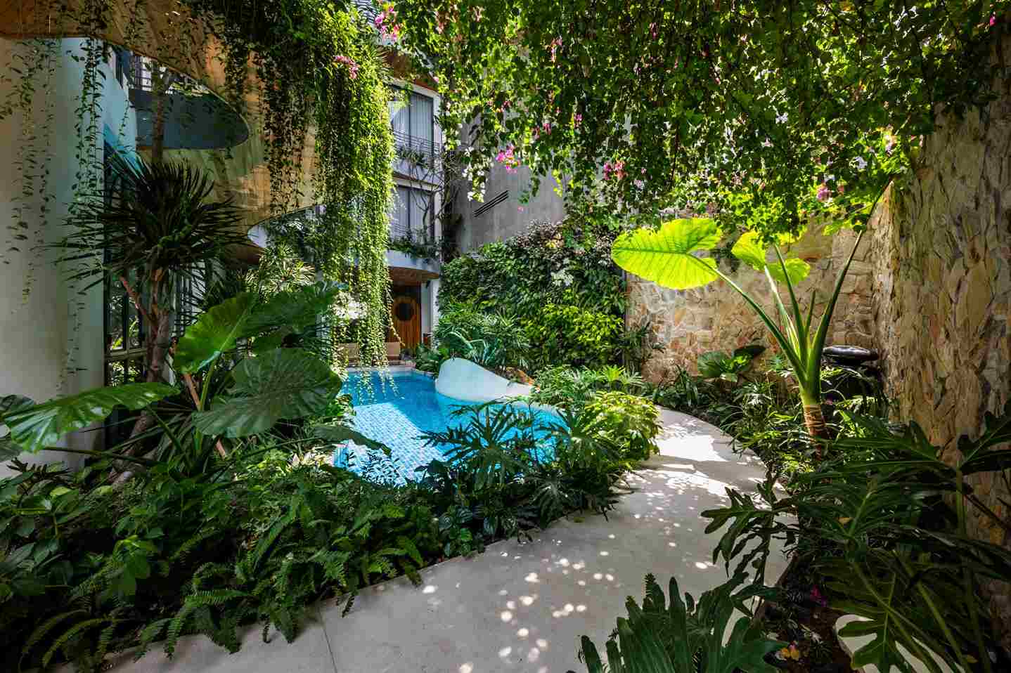 Sân Vườn Biệt Thự Nhiệt Đới: Bí Quyết Biến Nhà Phố Thành Resort Tại Gia 2 Hồ bơi và cây xanh trong sân vườn biệt thự nhiệt đới với thiết kế hòa quyện thiên nhiên.