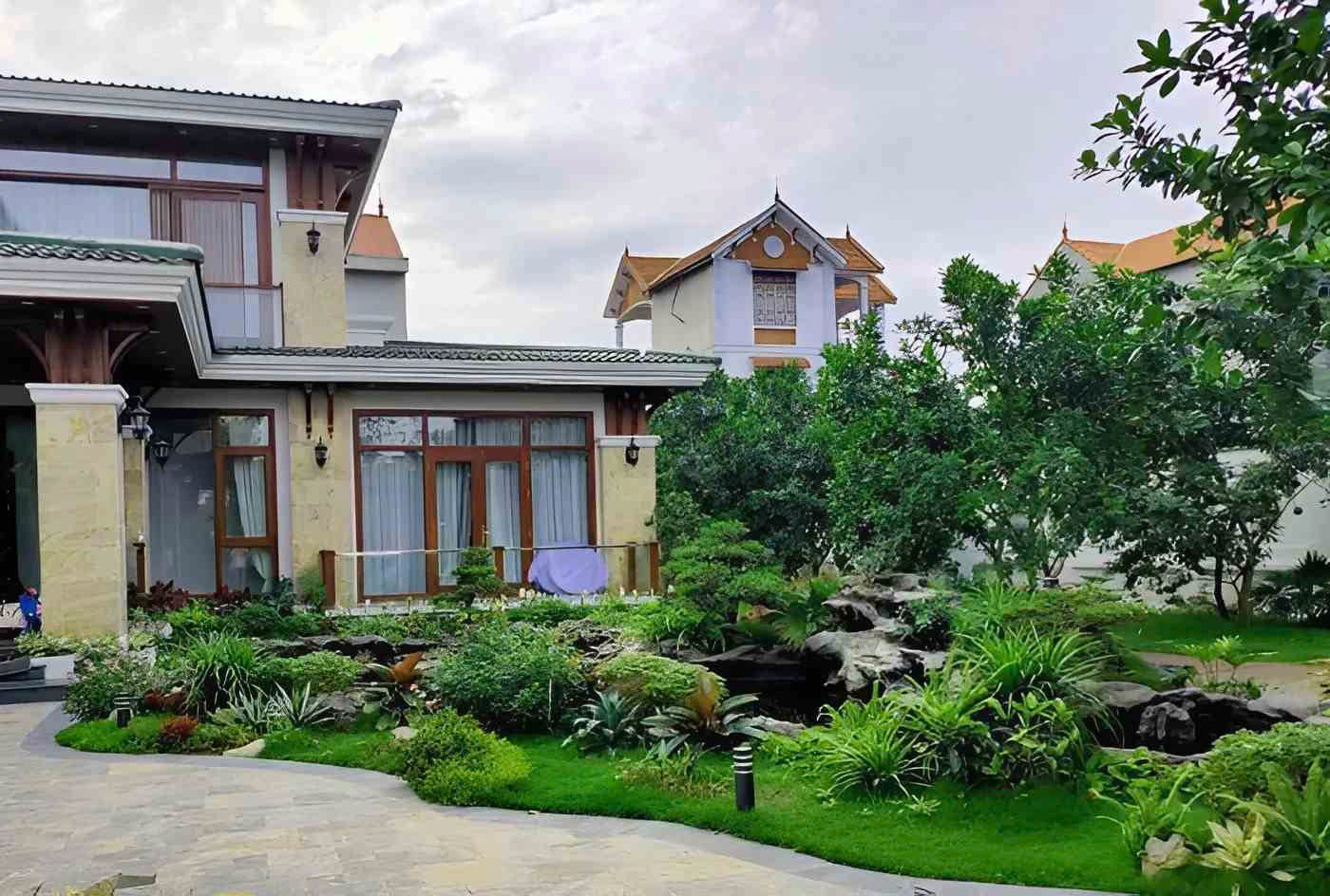 Thiết Kế Cảnh Quan Á Đông: Tạo Không Gian Sống Biết Thở, Biết Nghe 3 Cảnh quan Á Đông với hồ cá đá, cây bản địa và lối đi uốn lượn quanh biệt thự.